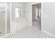 Elegant bathroom featuring a luxurious soaking tub, a glass-enclosed shower, and classic black and white tile flooring at 2517 Charter Oaks Dr, Mount Pleasant, SC 29466