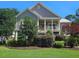 Charming two-story home with well-manicured lawn and lush landscaping, including a covered porch with white columns at 2517 Charter Oaks Dr, Mount Pleasant, SC 29466