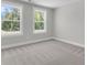 A bright bedroom featuring neutral carpet, double windows overlooking a serene landscape at 2807 Grange Cir, Summerville, SC 29486