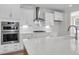 Close up on a bright, modern kitchen featuring white cabinets, quartz countertops, and stainless steel appliances at 2807 Grange Cir, Summerville, SC 29486