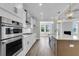Open concept kitchen with stainless steel appliances, island with sink, and view into adjacent dining and living space at 2807 Grange Cir, Summerville, SC 29486