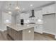 Modern kitchen with white cabinets, stainless steel appliances, island with quartz countertop, and designer lighting at 2807 Grange Cir, Summerville, SC 29486