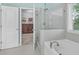 Spa-like bathroom with a soaking tub, glass-enclosed shower, and a walk-in closet at 307 Morning Marsh Ln, Charleston, SC 29492