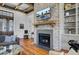 Cozy living room with a brick fireplace, wooden mantel, and hardwood floors creating a warm, inviting space at 307 Morning Marsh Ln, Charleston, SC 29492