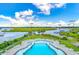 An aerial view of a pool and lounge area overlooking docks, lush foliage, and waterfront at 307 Morning Marsh Ln, Charleston, SC 29492