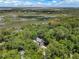 Aerial view of a home surrounded by lush trees, overlooking a scenic marsh and waterway at 3125 Privateer Creek Rd, Seabrook Island, SC 29455