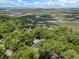 Aerial view of a home surrounded by lush trees, overlooking a scenic marsh and waterway at 3125 Privateer Creek Rd, Seabrook Island, SC 29455