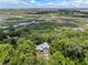 Aerial view of a home surrounded by lush trees, overlooking a scenic marsh and waterway at 3125 Privateer Creek Rd, Seabrook Island, SC 29455