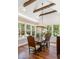 Elegant dining room with hardwood floors, wood beams, and ample natural light through large windows at 3125 Privateer Creek Rd, Seabrook Island, SC 29455