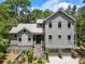 Charming two-story home with a grey exterior, a metal roof, and a well-manicured lawn at 3125 Privateer Creek Rd, Seabrook Island, SC 29455