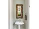 Chic powder room featuring a driftwood mirror, pedestal sink, and neutral wall color at 3125 Privateer Creek Rd, Seabrook Island, SC 29455