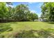 Expansive, well-maintained backyard with a mix of trees and lawn, a house and a fence at 3284 Sassy Dr, Johns Island, SC 29455