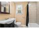 Well-lit bathroom features a vanity with a sink, toilet, a bathtub and shower combination with a window at 3284 Sassy Dr, Johns Island, SC 29455