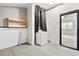Functional laundry room with washer, painted concrete walls, wood accent shelves, and view into bonus room at 3284 Sassy Dr, Johns Island, SC 29455