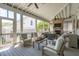 Comfortable screened-in porch with ample seating and a brick fireplace at 371 Bridgetown Pass, Mount Pleasant, SC 29464