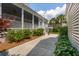 Landscaped backyard with a screened porch, lush greenery, and a serene walkway at 371 Bridgetown Pass, Mount Pleasant, SC 29464