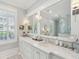 Bright bathroom with marble counters, double sinks, large mirrors and plantation shutters at 371 Bridgetown Pass, Mount Pleasant, SC 29464