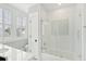 Bright bathroom features a bathtub with glass doors, tile details, and a white vanity at 371 Bridgetown Pass, Mount Pleasant, SC 29464