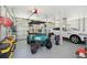 Well-organized garage showcases a golf cart, tools, and a modern vehicle, maximizing space and functionality at 371 Bridgetown Pass, Mount Pleasant, SC 29464