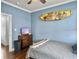 Bedroom with light blue walls, wood floor, ceiling fan, and surfboard decor at 4 Line St, Charleston, SC 29403