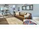 Open-concept living area featuring a stylish brown sofa, hardwood floors, and a view into the modern kitchen at 4 Line St, Charleston, SC 29403