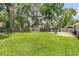 A spacious backyard features a well-manicured lawn, a privacy fence, mature trees, and a patio area with outdoor seating at 402 Woodward Blvd, Summerville, SC 29483