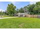 Side view of a single-story house with a well-manicured lawn, fenced yard, and driveway with a trailer at 402 Woodward Blvd, Summerville, SC 29483