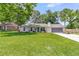 Charming single-story home with a well-manicured lawn and inviting curb appeal on a sunny day at 402 Woodward Blvd, Summerville, SC 29483