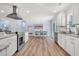 Well-lit kitchen features stainless appliances, island with bar seating, and view into the dining room at 402 Woodward Blvd, Summerville, SC 29483