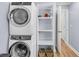 Convenient laundry room with modern, stacked appliances and ample shelving at 402 Woodward Blvd, Summerville, SC 29483