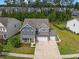 Beautiful home with manicured lawns, a long driveway, and a charming yellow front door with a spacious three-car garage at 443 Coopers Hawk Dr, Summerville, SC 29483
