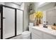 Well-lit bathroom featuring a glass-enclosed shower, white vanity, decorative mirror and stylish botanical accents at 443 Coopers Hawk Dr, Summerville, SC 29483