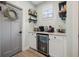 Charming coffee bar featuring white cabinets, granite countertops, floating shelves, and beverage storage, perfect for entertaining at 443 Coopers Hawk Dr, Summerville, SC 29483