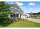 Two-story home featuring a well-manicured lawn, front porch, and long driveway at 443 Coopers Hawk Dr, Summerville, SC 29483