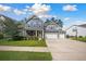 Beautiful two-story home with a yellow door, three car garage, and manicured lawn at 443 Coopers Hawk Dr, Summerville, SC 29483