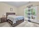 Bedroom with a door to a wooden deck surrounded by trees and a queen bed with gray wood frame at 4630 Palm View Cir, North Charleston, SC 29418