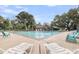 Relaxing pool with lounge chairs, offering a refreshing oasis and a community building view at 4630 Palm View Cir, North Charleston, SC 29418