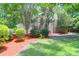 A spacious yard with landscaping, mature trees, and a wooden fence for privacy at 4752 Trailside Ct # B, North Charleston, SC 29418