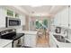 Full view of updated kitchen with stainless appliances, white cabinets, and adjacent dining area at 4856 Green Dolphin Way # Share 5, Kiawah Island, SC 29455
