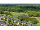 A lush neighborhood with a golf course, serene pond, mature trees, and well-maintained homes, from above at 5256 Mulholland Dr, Summerville, SC 29485