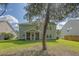 Exterior view of the home showcasing the large yard and screened-in porch at 5256 Mulholland Dr, Summerville, SC 29485