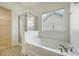 Bathroom with tile floor, walk-in closet, walk-in shower and soaking tub under window at 5256 Mulholland Dr, Summerville, SC 29485
