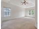 Spacious bedroom with neutral carpet, tray ceiling, ceiling fan, and windows for ample natural light at 5256 Mulholland Dr, Summerville, SC 29485