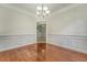 Inviting dining room with elegant wainscoting, hardwood floors, and an open view to another room at 5256 Mulholland Dr, Summerville, SC 29485
