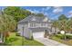 Beautiful two-story home with a manicured lawn, mature trees, and a two-car garage, showcasing curb appeal at 5256 Mulholland Dr, Summerville, SC 29485