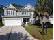 Charming two-story home boasts a manicured lawn, two car garage, and appealing architectural details at 5256 Mulholland Dr, Summerville, SC 29485