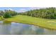 Scenic golf course view with a tranquil pond, lush green fairway, and mature trees in the background at 5256 Mulholland Dr, Summerville, SC 29485