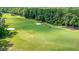Scenic golf course view featuring lush green fairways, mature trees, sand traps and a golfer pulling their clubs at 5256 Mulholland Dr, Summerville, SC 29485
