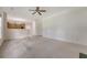 Open living room with neutral carpet and a view into the kitchen, plus a ceiling fan at 5256 Mulholland Dr, Summerville, SC 29485