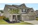 Two-story home showcasing neutral siding, brick accents, a two-car garage and a beautifully landscaped front yard at 528 Fern Tree Dr, Summerville, SC 29486